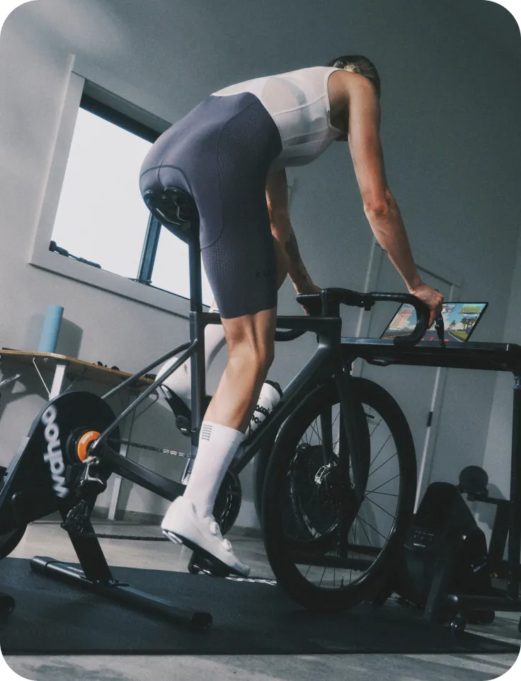 A cyclist mid-workout on an indoor trainer with targets displayed